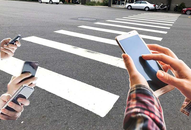 廈門將禁止過馬路時，於斑馬線上滑手機，違法將被處以警告或人民幣50元罰款。圖／編輯部